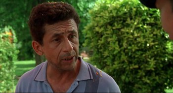 Movie still from “Monsoon Wedding” (2001), directed by Mira Nair – A person wearing a blue shirt near a bush; Close Up shot, Low angle