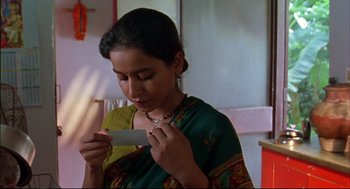 Movie still from “Monsoon Wedding” (2001), directed by Mira Nair – A woman in a sari looking at a piece of paper; Close Up shot, Low angle