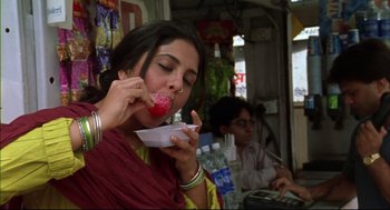 Movie still from “Monsoon Wedding” (2001), directed by Mira Nair – A woman eating a bowl of food while sitting in a booth; Close Up shot, Low angle