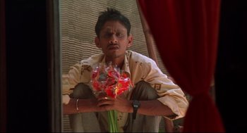 Movie still from “Monsoon Wedding” (2001), directed by Mira Nair – A man holding a bouquet of flowers in his hands; Medium shot, Low angle