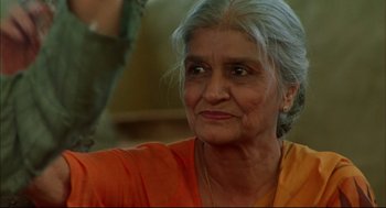 Movie still from “Monsoon Wedding” (2001), directed by Mira Nair – An older woman in an orange shirt looks at the camera; Close Up shot, Low angle
