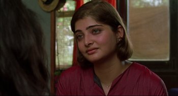 Movie still from “Monsoon Wedding” (2001), directed by Mira Nair – A young woman in a red shirt is looking at the camera; Close Up shot, Over the shoulder angle