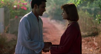Movie still from “Monsoon Wedding” (2001), directed by Mira Nair – A man and a woman holding hands in a field; Medium shot, Low angle