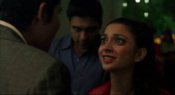 Movie still from “Monsoon Wedding” (2001), directed by Mira Nair – A group of people standing next to each other in a room; Close Up shot, Over the shoulder angle