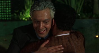 Movie still from “Monsoon Wedding” (2001), directed by Mira Nair – A man hugging another man in the dark; Close Up shot, Over the shoulder angle