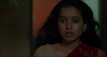 Movie still from “Monsoon Wedding” (2001), directed by Mira Nair – A woman with long black curly hair wearing a red sari; Close Up shot, High angle