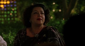 Movie still from “Monsoon Wedding” (2001), directed by Mira Nair – An older woman wearing a black dress and a necklace; Close Up shot, Over the shoulder angle