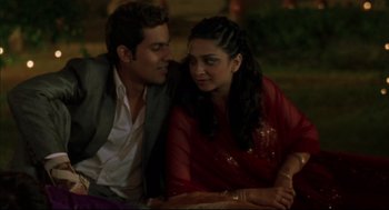 Movie still from “Monsoon Wedding” (2001), directed by Mira Nair – A man and a woman sitting next to each other; Medium shot, High angle