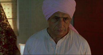 Movie still from “Monsoon Wedding” (2001), directed by Mira Nair – An older man wearing a pink turban and a white shirt; Close Up shot, Low angle