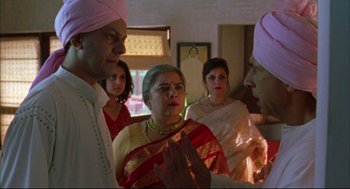 Movie still from “Monsoon Wedding” (2001), directed by Mira Nair – A group of people standing in a room; Medium shot, Over the shoulder angle