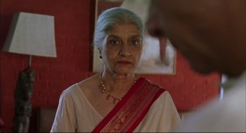Movie still from “Monsoon Wedding” (2001), directed by Mira Nair – An older woman wearing a red and white sari; Close Up shot, Low angle