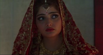 Movie still from “Monsoon Wedding” (2001), directed by Mira Nair – A woman in a red and gold dress with a veil; Close Up shot, Over the shoulder angle