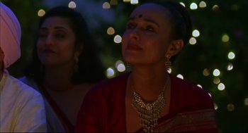 Movie still from “Monsoon Wedding” (2001), directed by Mira Nair – A woman in a red dress and a gold necklace; Close Up shot, Low angle