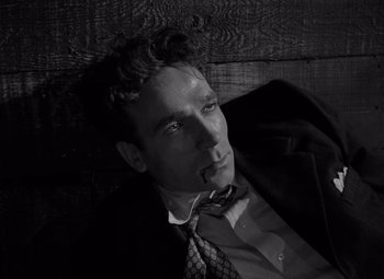 Movie still from “Moonrise” (1948), directed by Frank Borzage – Black and white photograph of a man in a suit and tie; Close Up shot, High angle