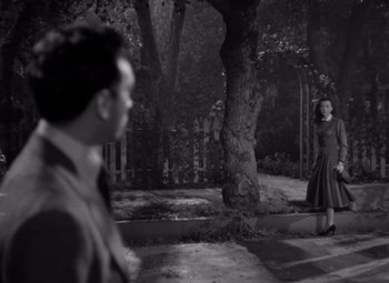 Movie still from “Moonrise” (1948), directed by Frank Borzage – A man and a woman standing in front of a tree; Wide shot, Over the shoulder angle