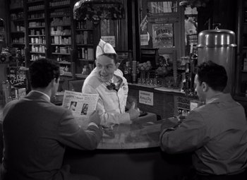 Movie still from “Moonrise” (1948), directed by Frank Borzage – Three men sitting at a counter in a store; Medium shot, High angle