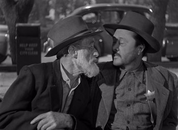 Movie still from “Moonrise” (1948), directed by Frank Borzage – Two men in hats are sitting next to each other; Medium shot, Over the shoulder angle