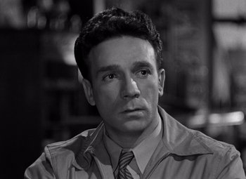 Movie still from “Moonrise” (1948), directed by Frank Borzage – Black and white photograph of a man in a suit and tie; Close Up shot, High angle