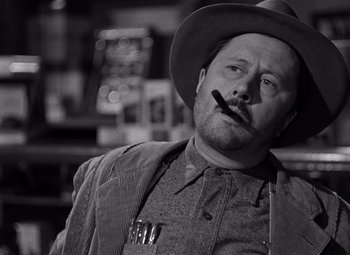 Movie still from “Moonrise” (1948), directed by Frank Borzage – A black and white photo of a man smoking a pipe; Close Up shot, Low angle