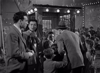 Movie still from “Moonrise” (1948), directed by Frank Borzage – A group of people standing next to each other in a room; Medium shot, Low angle