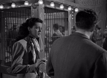 Movie still from “Moonrise” (1948), directed by Frank Borzage – A woman standing next to a man in front of a cage; Medium shot, Low angle