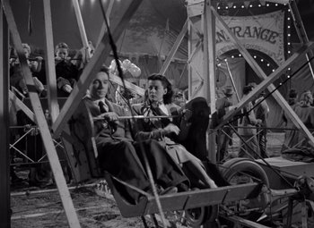 Movie still from “Moonrise” (1948), directed by Frank Borzage – A man and a woman riding a ferris wheel; Wide shot, High angle