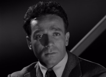 Movie still from “Moonrise” (1948), directed by Frank Borzage – Black and white photograph of a man wearing a suit and tie; Close Up shot, High angle