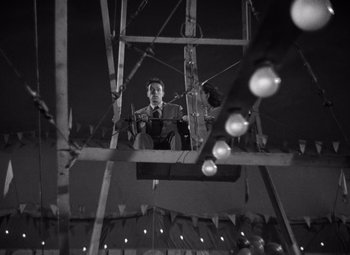 Movie still from “Moonrise” (1948), directed by Frank Borzage – A man is sitting on a wooden structure; Wide shot, Low angle