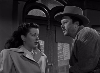 Movie still from “Moonrise” (1948), directed by Frank Borzage – A man and a woman standing next to each other in front of a building; Close Up shot, Low angle