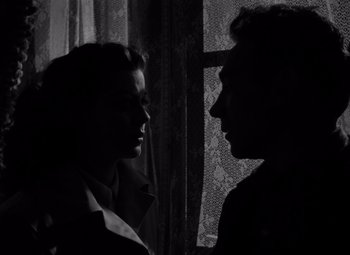 Movie still from “Moonrise” (1948), directed by Frank Borzage – A man and a woman face to face in front of a window; Close Up shot, Low angle