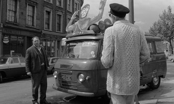 Movie still from “Morgan!” (1966), directed by Karel Reisz – An older man standing next to an old bus; Wide shot, Low angle