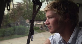 Movie still from “Morning Light” (2008), directed by Mark Monroe – A young man looking out the window of a vehicle; Close Up shot, Low angle