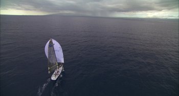 Movie still from “Morning Light” (2008), directed by Mark Monroe – An aerial view of a sailboat in the ocean; Extreme Wide shot, Overhead angle
