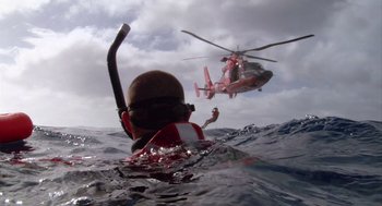 Movie still from “Morning Light” (2008), directed by Mark Monroe – A person in the water and a helicopter in the air; Wide shot, Low angle