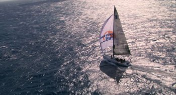 Movie still from “Morning Light” (2008), directed by Mark Monroe – A sailboat sailing on a body of water at sunset; Extreme Wide shot, Low angle