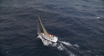 Movie still from “Morning Light” (2008), directed by Mark Monroe – A sailboat sailing on a large body of water; Extreme Wide shot, Overhead angle