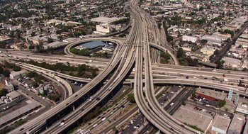 Movie still from “Morning Light” (2008), directed by Mark Monroe – An aerial view of an intersection in a metropolitan area; Extreme Wide shot, High angle