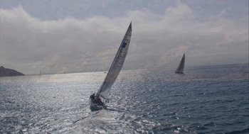 Movie still from “Morning Light” (2008), directed by Mark Monroe – Two sailboats in the ocean on a cloudy day; Extreme Wide shot, Low angle