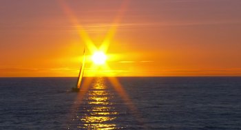 Movie still from “Morning Light” (2008), directed by Mark Monroe – A sail boat sailing on a body of water at sunset; Extreme Wide shot, Low angle