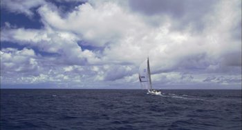 Movie still from “Morning Light” (2008), directed by Mark Monroe – A sailboat sailing on the ocean under a cloudy sky; Extreme Wide shot, Low angle