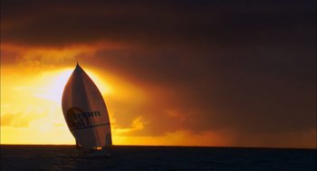 Movie still from “Morning Light” (2008), directed by Mark Monroe – A sailboat sailing on a body of water at sunset; Extreme Wide shot, Low angle