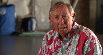 Movie still from “Morning Light” (2008), directed by Mark Monroe – An older man wearing a red and blue hawaiian shirt; Close Up shot, Low angle