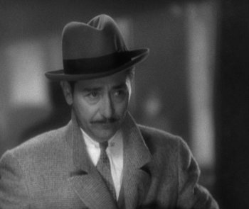 Movie still from “Morocco” (1930), directed by Josef von Sternberg – A man wearing a suit and a hat; Close Up shot, High angle