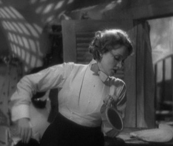 Movie still from “Morocco” (1930), directed by Josef von Sternberg – A black and white photo of a woman holding a mirror; Medium shot, Low angle