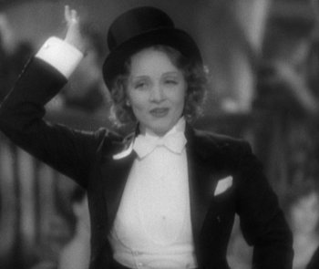 Movie still from “Morocco” (1930), directed by Josef von Sternberg – A black and white photo of a woman wearing a top hat; Medium shot, Low angle
