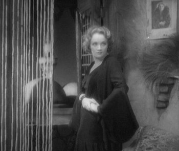 Movie still from “Morocco” (1930), directed by Josef von Sternberg – A black and white photo of a woman in a black dress; Medium shot, Over the shoulder angle