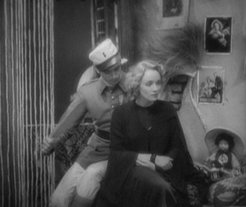 Movie still from “Morocco” (1930), directed by Josef von Sternberg – A man and a woman sitting on a couch; Medium shot, High angle