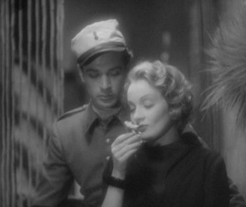 Movie still from “Morocco” (1930), directed by Josef von Sternberg – A man and a woman are looking at a flower; Medium shot, Over the shoulder angle