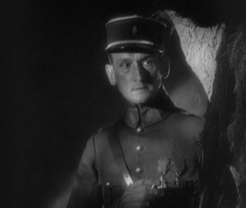 Movie still from “Morocco” (1930), directed by Josef von Sternberg – A man in a uniform is standing in front of a tree; Close Up shot, Low angle