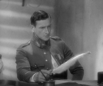 Movie still from “Morocco” (1930), directed by Josef von Sternberg – An old photo of a man in uniform writing on a piece of paper; Close Up shot, High angle